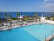 Rooftop pool with ocean views, surrounded by lounge chairs and palm trees at 540 N Tamiami Trl # 1503, Sarasota, FL 34236