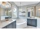 Elegant bathroom boasts dual marble vanities, soaking tub, and stylish chandelier at 5515 Simonton St, Bradenton, FL 34203