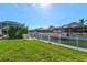 A waterfront backyard features a seawall, a manicured lawn, and a white fence at 556 Regatta Way, Bradenton, FL 34208