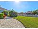 Lush backyard featuring a paver patio, green lawn, and views of the waterfront and surrounding homes at 556 Regatta Way, Bradenton, FL 34208