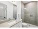 Modern bathroom with a mosaic-tiled shower, a sleek vanity, and a large mirror at 556 Regatta Way, Bradenton, FL 34208