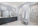 Luxurious bathroom featuring a double vanity, marble floors, and frameless glass shower at 556 Regatta Way, Bradenton, FL 34208