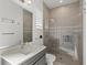Well-lit bathroom with a modern vanity, a glass-enclosed shower, and neutral tile throughout at 556 Regatta Way, Bradenton, FL 34208