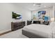 Modern bedroom featuring a sleek dresser, TV, ceiling fan, large wall art and comfortable seating area at 556 Regatta Way, Bradenton, FL 34208