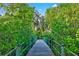 Scenic wooden boardwalk surrounded by lush greenery and trees at 556 Regatta Way, Bradenton, FL 34208