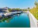 A tranquil waterfront home showcases a private dock with a boat, blending luxury with nature at 556 Regatta Way, Bradenton, FL 34208