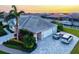 Paver driveway leading to a three-car garage, complemented by mature landscaping and vibrant flowers at 556 Regatta Way, Bradenton, FL 34208