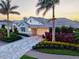 Exterior home view showcases lush landscaping, a paver driveway, and a two-car garage at 556 Regatta Way, Bradenton, FL 34208