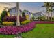 Beautiful home exterior with manicured lawn, colorful flowers, tropical landscaping, and stone accents at 556 Regatta Way, Bradenton, FL 34208