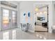 Bright foyer with a modern glass table, tile floors, and an open doorway to the living room at 556 Regatta Way, Bradenton, FL 34208