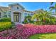 Charming front entrance adorned with colorful flowers, manicured shrubs, and a well-maintained lawn at 556 Regatta Way, Bradenton, FL 34208