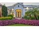 Charming front entrance with a well-manicured garden, palm tree, and double front door entrance at 556 Regatta Way, Bradenton, FL 34208