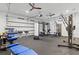 Home gym featuring various strength and cardio equipment set up in garage with ceiling fans and bright lighting at 556 Regatta Way, Bradenton, FL 34208