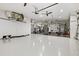 Large garage converted into a home gym, featuring epoxy floors, exercise equipment, and ceiling fans at 556 Regatta Way, Bradenton, FL 34208