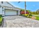 Two-car garage with paver driveway, complemented by vibrant landscaping and well-manicured lawn at 556 Regatta Way, Bradenton, FL 34208