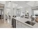 Bright kitchen featuring a large island with quartz countertops, stainless steel sink, and a wine refrigerator at 556 Regatta Way, Bradenton, FL 34208