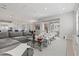 Open-concept living room with gray couch, modern chairs, and view of kitchen and dining area at 556 Regatta Way, Bradenton, FL 34208