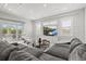 Bright living room featuring a gray couch, white armchairs, and a glass coffee table near sliding glass doors at 556 Regatta Way, Bradenton, FL 34208