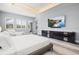 Inviting bedroom with a large bed, modern dresser, and sun-filled windows at 556 Regatta Way, Bradenton, FL 34208