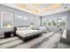 Spacious main bedroom with tray ceiling, plantation shutters, and a cozy seating area at 556 Regatta Way, Bradenton, FL 34208