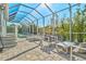 A covered outdoor pool area featuring a pool, outdoor seating, and a brick floor at 556 Regatta Way, Bradenton, FL 34208