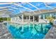 Backyard with an enclosed pool and an attached spa features blue tiling and poolside lounging at 556 Regatta Way, Bradenton, FL 34208