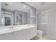 Bright bathroom featuring double sinks, a large mirror, and a glass-enclosed shower at 5609 Modena Pl, Sarasota, FL 34238