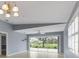 This well-lit living room has tile flooring and lots of natural light from a sliding glass door and window at 5609 Modena Pl, Sarasota, FL 34238
