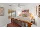 Bright bedroom with white walls, wooden bed frame, ceiling fan, and view through the window at 5694 Palmer Cir # 204, Lakewood Ranch, FL 34211