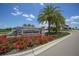 Inviting entrance to Lakewood National, featuring vibrant flowers, mature palm trees, and a welcoming stone sign at 5694 Palmer Cir # 204, Lakewood Ranch, FL 34211