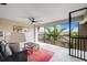Inviting lanai with seating, ceiling fan, and view of tropical foliage and neighboring rooftops at 5694 Palmer Cir # 204, Lakewood Ranch, FL 34211