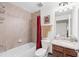 Well-lit bathroom featuring a tub with a shower, granite vanity, modern fixtures, and neutral tile at 5694 Palmer Cir # 204, Lakewood Ranch, FL 34211