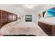 Serene bedroom with a wooden headboard, soft bedding, and a wall mounted television at 5694 Palmer Cir # 204, Lakewood Ranch, FL 34211