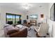 The open concept living area offers access to the lanai and boasts comfortable furnishings and natural light at 5694 Palmer Cir # 204, Lakewood Ranch, FL 34211