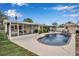 Serene backyard featuring a sparkling pool, screened patio, and lush green landscaping at 5808 18Th W St # A & B, Bradenton, FL 34207