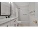 Bright, clean bathroom featuring a white vanity with marble countertop, shower-tub with white tile, and bronze hardware at 5808 18Th W St # A & B, Bradenton, FL 34207