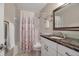 Bathroom with marble countertop vanity and shower with floral curtain at 5808 18Th W St # A & B, Bradenton, FL 34207
