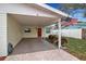 Covered carport area with a red door entrance and well-kept landscaping at 5808 18Th W St # A & B, Bradenton, FL 34207