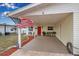 Covered carport with a red door, outdoor seating, and manicured landscaping at 5808 18Th W St # A & B, Bradenton, FL 34207