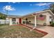 Charming single-story home featuring a covered parking area, red door, and an American flag at 5808 18Th W St # A & B, Bradenton, FL 34207