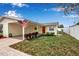 Single-story home featuring a covered carport, red door, and tidy front yard at 5808 18Th W St # A & B, Bradenton, FL 34207
