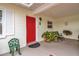 Charming front porch with a bright red door, elegant decor, and a cozy bench at 5808 18Th W St # A & B, Bradenton, FL 34207