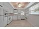 All-white kitchen features stainless steel appliances, a window, an exterior door and open shelving at 5808 18Th W St # A & B, Bradenton, FL 34207