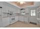 All-white kitchen features stainless steel appliances, a window, and an exterior door at 5808 18Th W St # A & B, Bradenton, FL 34207