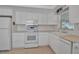 All-white kitchen featuring stainless steel appliances, a window, and beige countertops at 5808 18Th W St # A & B, Bradenton, FL 34207
