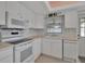 All-white kitchen featuring stainless steel appliances, a window, and beige countertops at 5808 18Th W St # A & B, Bradenton, FL 34207