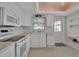 All-white kitchen featuring stainless steel appliances, a window, and beige countertops at 5808 18Th W St # A & B, Bradenton, FL 34207