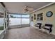 An enclosed patio has tile floors, a ceiling fan, and an exterior door leading into the backyard at 5808 18Th W St # A & B, Bradenton, FL 34207