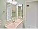 Bathroom vanity with sink, mirrors, and a view into the shower at 6023 Mayberry Ave, North Port, FL 34287