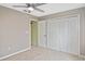 Bedroom with carpet, ceiling fan, closet doors, and door leading to the hallway at 6023 Mayberry Ave, North Port, FL 34287